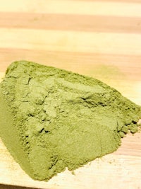 a pile of green powder on a cutting board