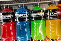 a row of bottles of powerade are lined up on a shelf